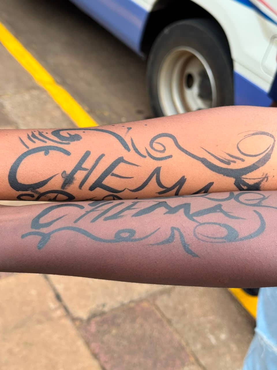 Chema fans display bold club-themed arm markings outside the arena.