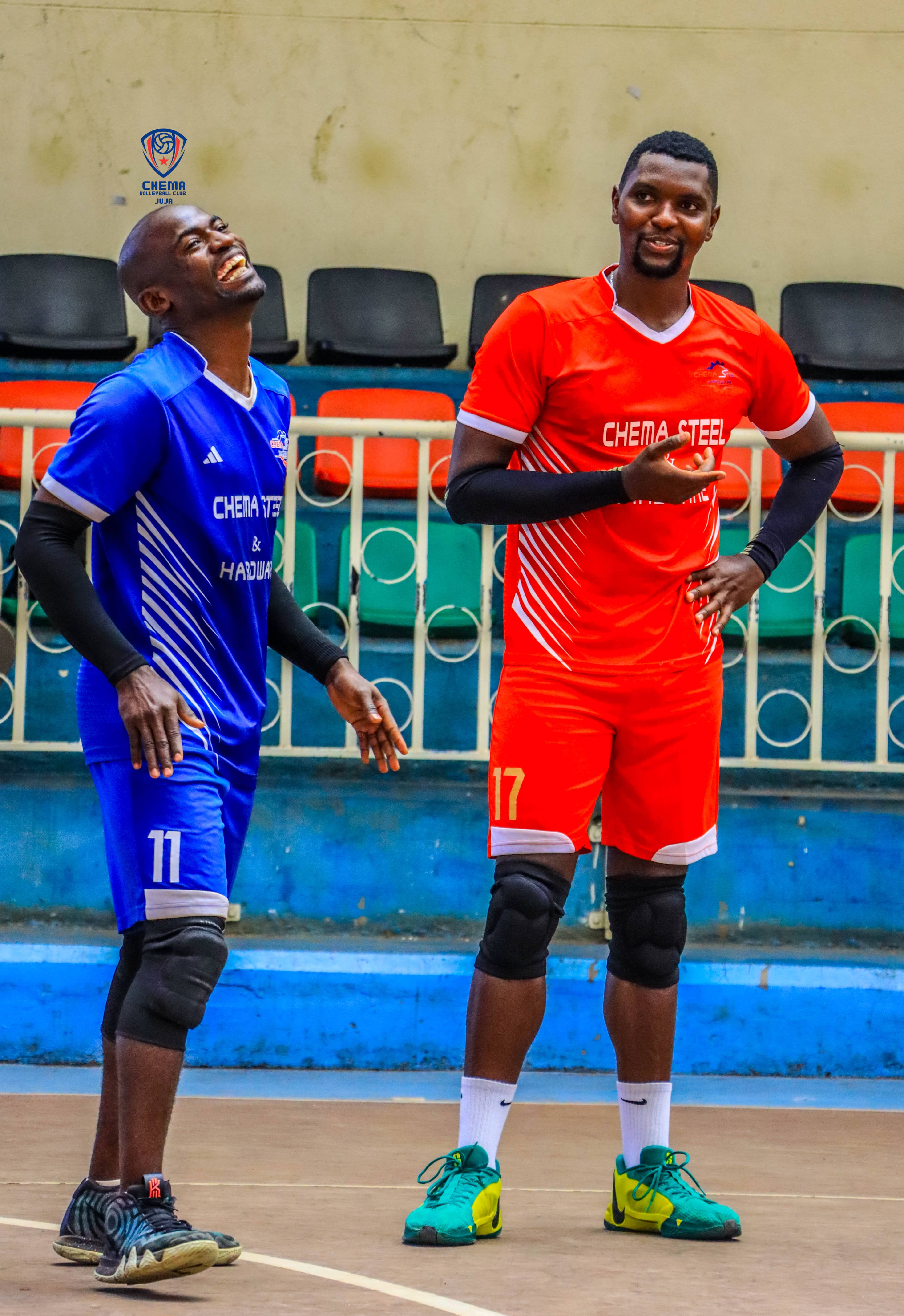 Two Chema players share a smile on court in blue and red club kit.