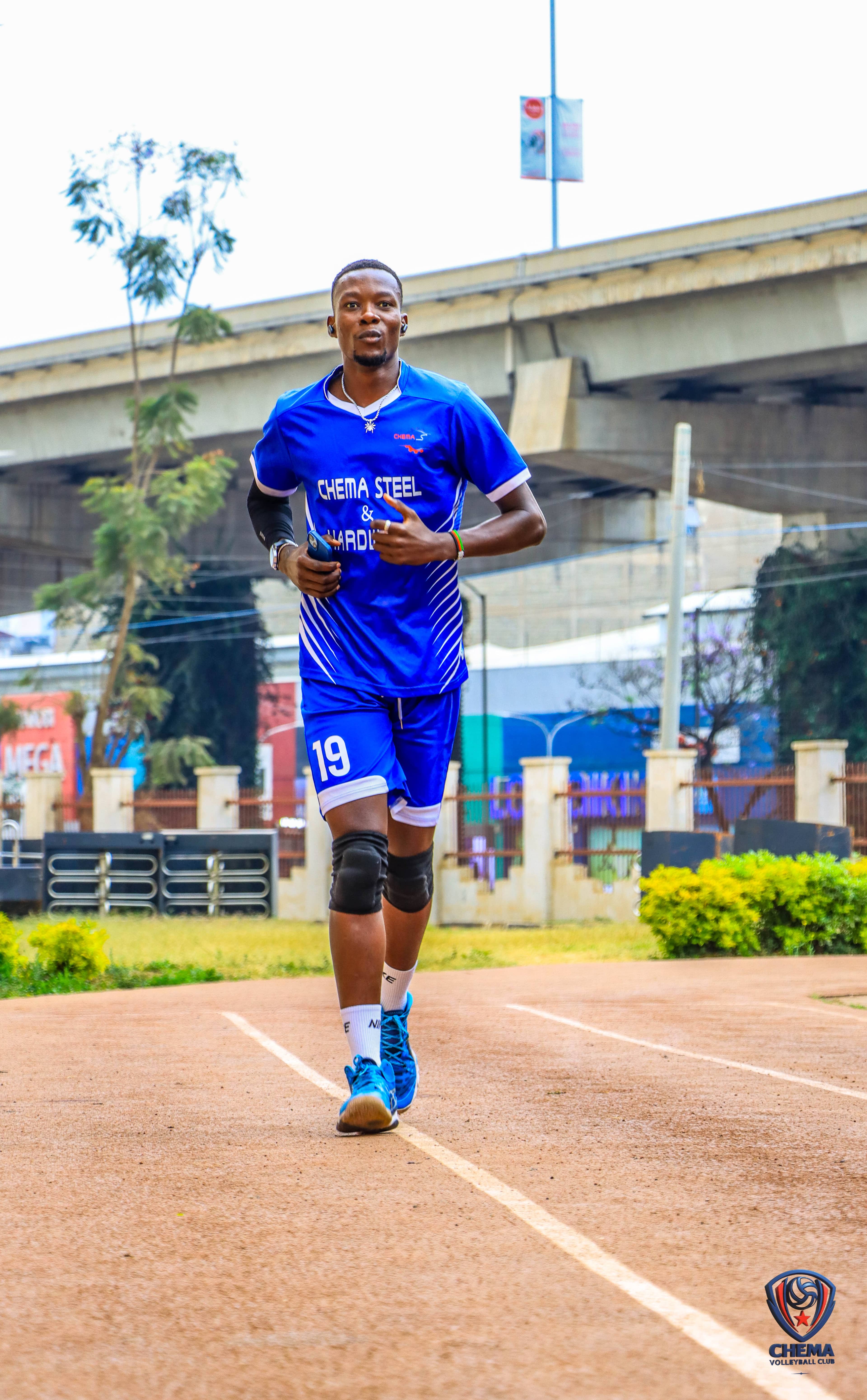 A Chema player in blue kit jogs on an outdoor court.